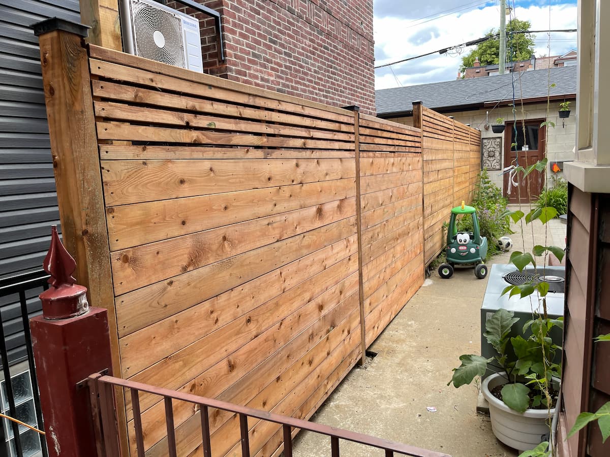Horizontal pressure-treated privacy fence with slatted top by Aloe Decks, fence builder serving Barrie and Simcoe County, Ontario
